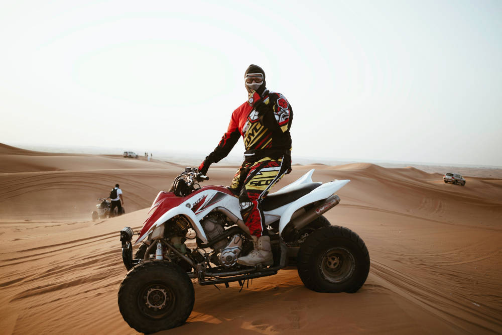 red and white atv on sand dunes