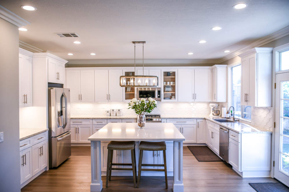 white kitchen with island and recessed lighting