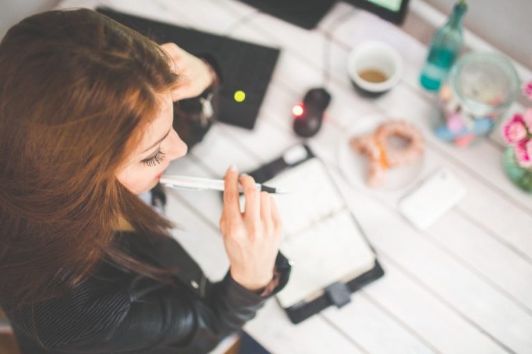 lady sitting at table with pen in hand