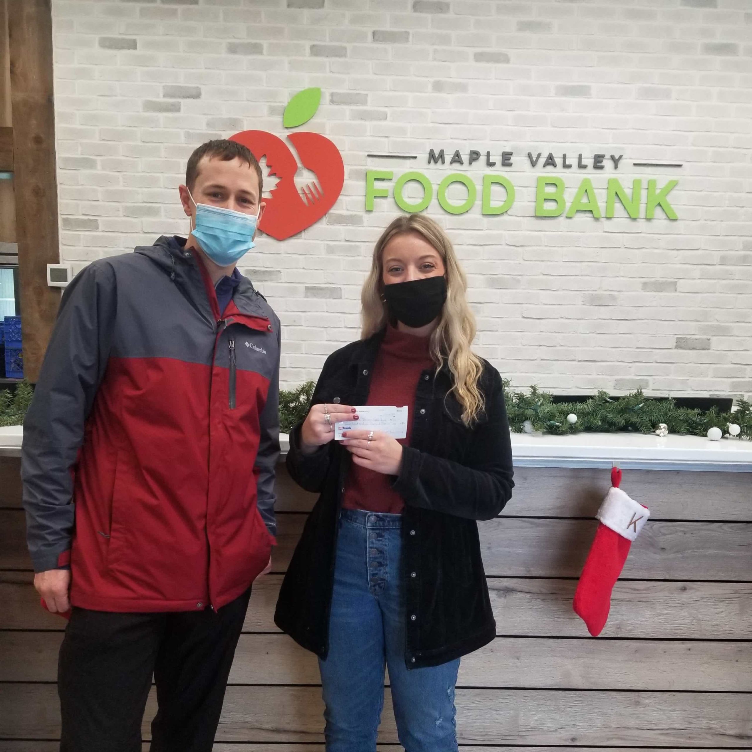 Ryan Stueber from PNW Insurance Group dropping off donation check to Maple Valley Food Bank