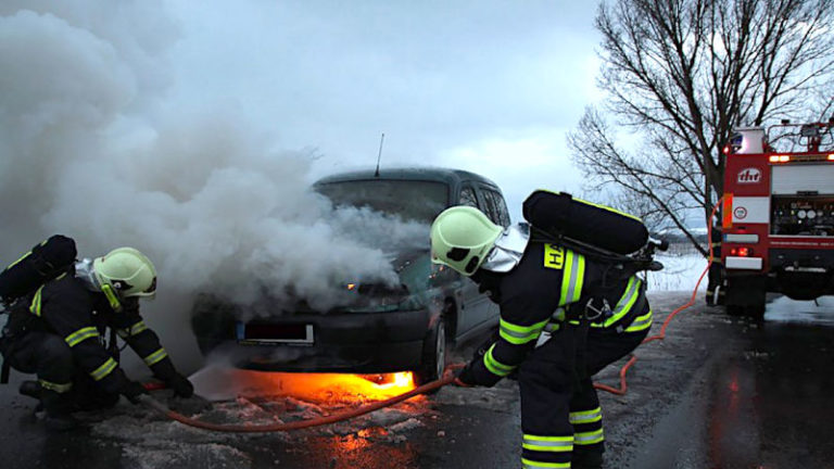 fire fighters extinguishing car on fire