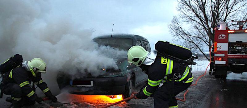 fire fighters extinguishing car on fire
